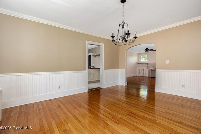 58 Old Loudon Rd, Colonie, NY 12110 - spare room with wainscoting, arched walkways, a chandelier, light wood-style flooring, and ceiling fan