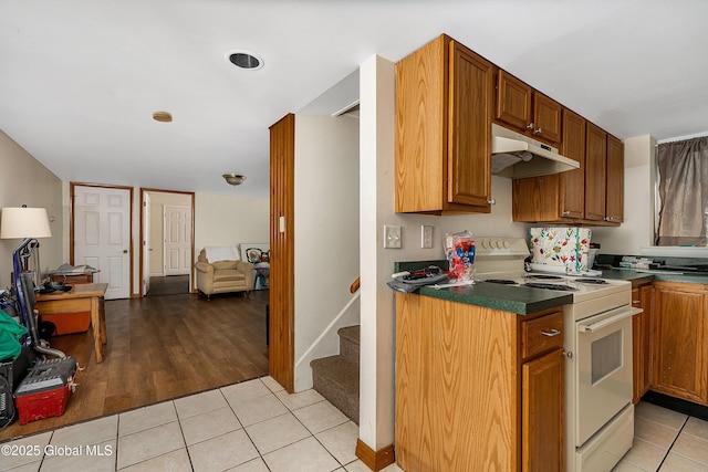58 Old Loudon Rd, Colonie, NY 12110 - kitchen featuring electric range, under cabinet range hood, light tile patterned floors, and dark countertops