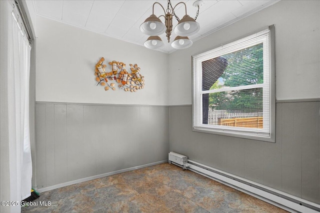 302 S William St, Johnstown, NY 12095 - unfurnished room featuring a baseboard radiator, a chandelier, wainscoting, stone finish flooring, and wood walls