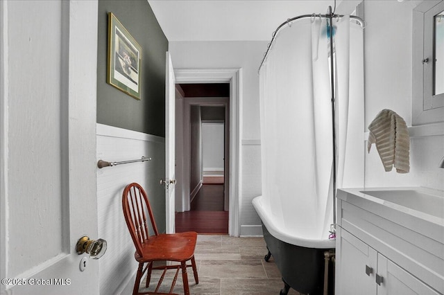 302 S William St, Johnstown, NY 12095 - bathroom featuring a freestanding bath, vanity, wood finished floors, and curtained shower