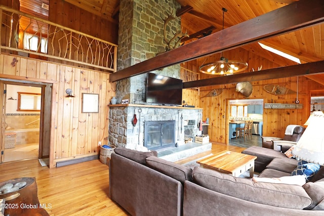 745 Adirondack Rd, Schroon Lake, NY 12870 - living room featuring wooden walls, wooden ceiling with exposed beams, hardwood / wood-style floors, a fireplace, and a baseboard heating unit