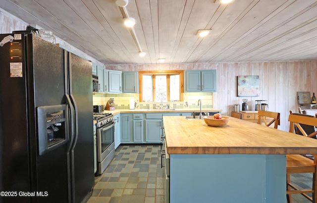 745 Adirondack Rd, Schroon Lake, NY 12870 - kitchen with appliances with stainless steel finishes, wooden counters, a sink, and a center island with sink