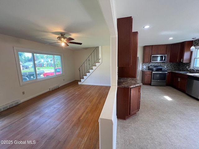 44 Park Ave, Colonie, NY 12110 - kitchen with appliances with stainless steel finishes, open floor plan, ceiling fan, tasteful backsplash, and dark stone countertops