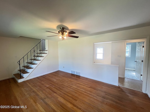 44 Park Ave, Colonie, NY 12110 - unfurnished living room featuring a ceiling fan, wood finished floors, and stairway