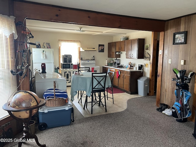 11 Williams St, Granville, NY 12832 - kitchen featuring white appliances, range hood, wooden walls, light countertops, and light carpet