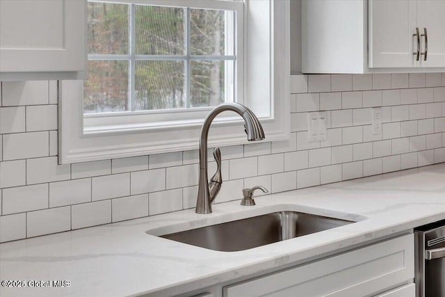 24 Nichols Rd, Wilton, NY 12831 - kitchen view of a sink, white cabinets, tasteful backsplash, light stone counters, and stainless steel dishwasher