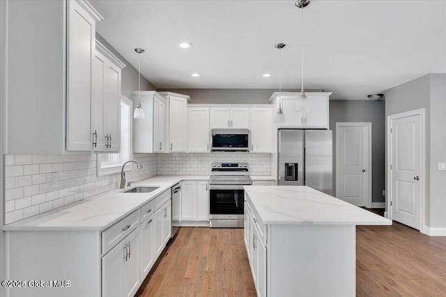 24 Nichols Rd, Wilton, NY 12831 - kitchen with stainless steel appliances, a sink, a center island, tasteful backsplash, and light wood finished floors