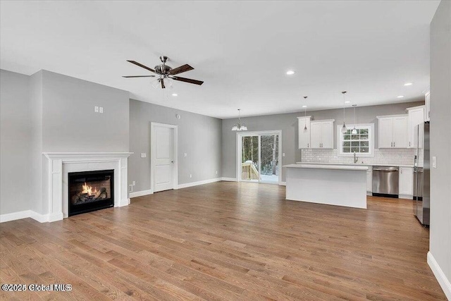 24 Nichols Rd, Wilton, NY 12831 - unfurnished living room with a ceiling fan, a glass covered fireplace, wood finished floors, recessed lighting, and baseboards