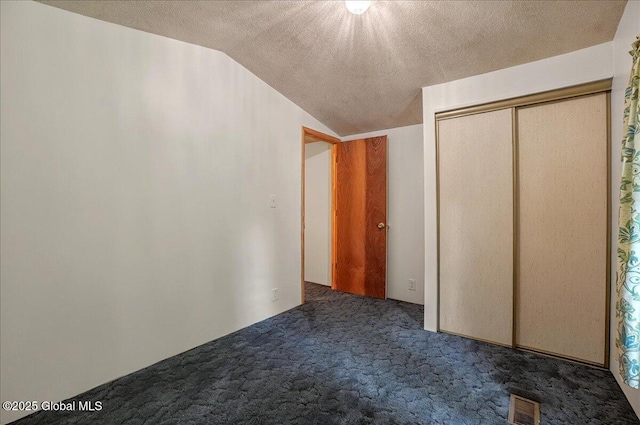 207 State Highway 5s, Florida, NY 12137 - unfurnished bedroom with dark colored carpet, vaulted ceiling, a textured ceiling, and a closet