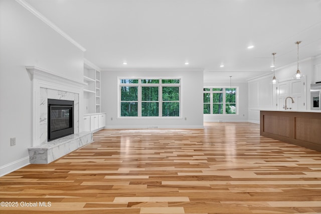 480 Selfridge Rd, Moreau, NY 12831 - unfurnished living room featuring light wood-style flooring, ornamental molding, built in features, a high end fireplace, and recessed lighting