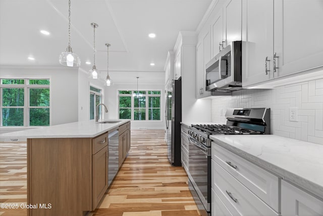 480 Selfridge Rd, Moreau, NY 12831 - kitchen with stainless steel appliances, light wood-style floors, a kitchen island with sink, decorative backsplash, and white cabinets