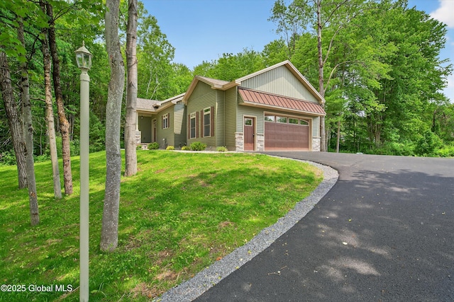 480 Selfridge Rd, Moreau, NY 12831 - view of front facade featuring an attached garage, a front yard, stone siding, driveway, and a standing seam roof