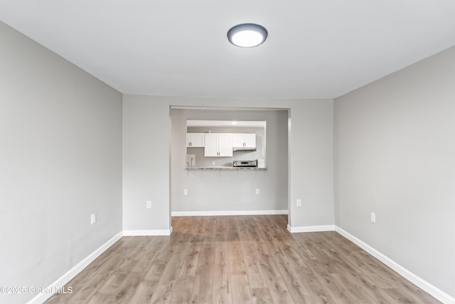 unfurnished living room with light wood-style flooring and baseboards