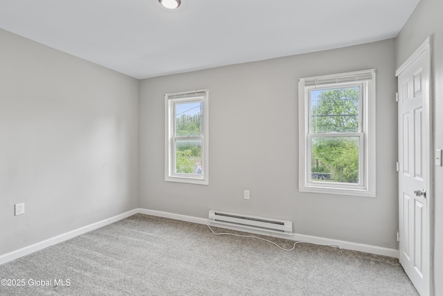 carpeted spare room with baseboard heating and baseboards