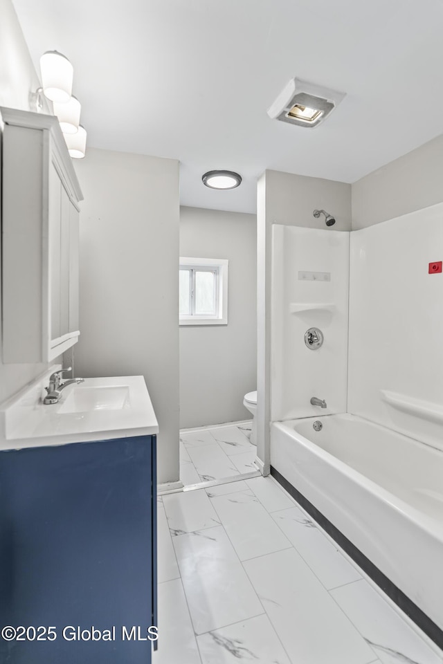 bathroom featuring toilet, vanity, marble look tile flooring, and shower / tub combination