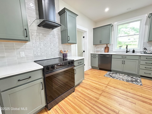 354 Mohawk Ave, Scotia, NY 12302 - kitchen featuring dishwasher, black / electric stove, a sink, wall chimney range hood, and light wood-style floors