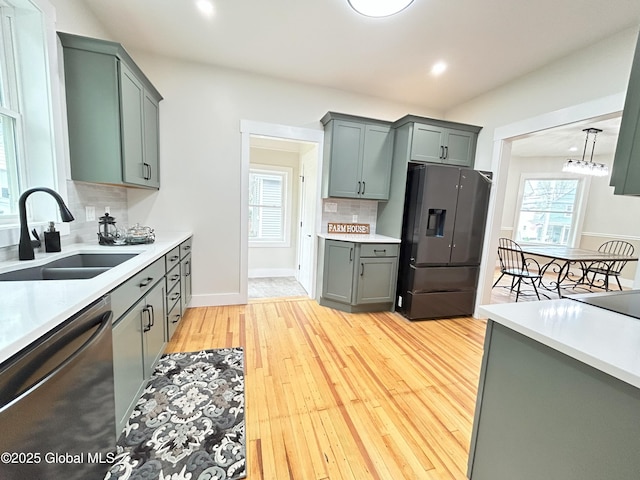 354 Mohawk Ave, Scotia, NY 12302 - kitchen with stainless steel appliances, a sink, decorative backsplash, light countertops, and light wood-type flooring