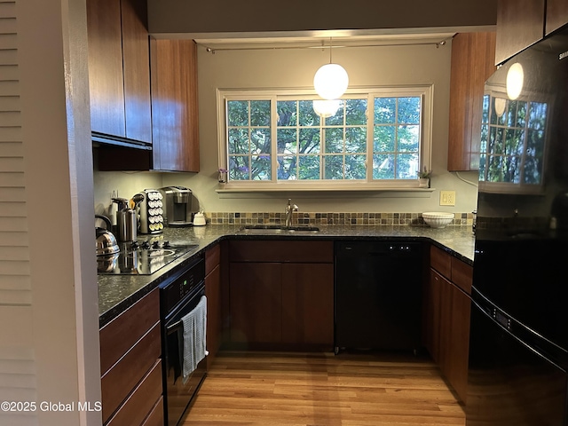 33 Oak Rd, Bethlehem, NY 12054 - kitchen featuring black appliances, a sink, dark stone countertops, light wood-style floors, and decorative light fixtures