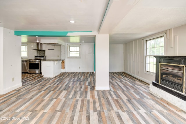 676 Stoner Trail Rd, Mohawk, NY 12068 - unfurnished living room featuring baseboards, a fireplace, wood finished floors, recessed lighting, and plenty of natural light