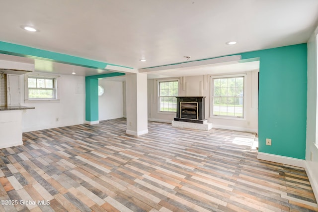 676 Stoner Trail Rd, Mohawk, NY 12068 - unfurnished living room featuring a premium fireplace, recessed lighting, plenty of natural light, baseboards, and light wood-style floors