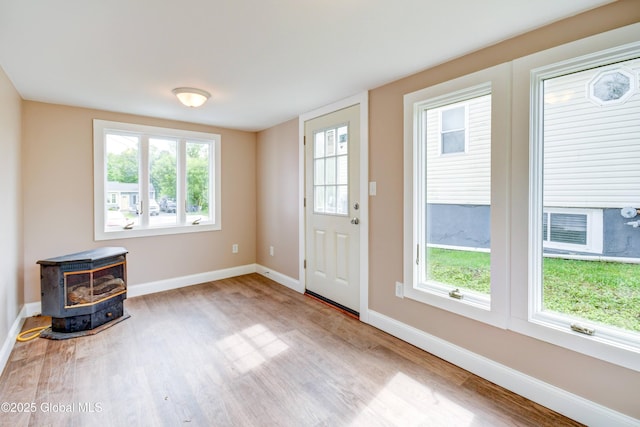 676 Stoner Trail Rd, Mohawk, NY 12068 - foyer entrance featuring a wood stove, wood finished floors, and baseboards