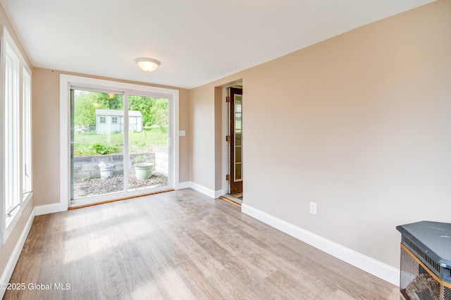 676 Stoner Trail Rd, Mohawk, NY 12068 - empty room featuring light wood-style flooring, baseboards, and a wood stove