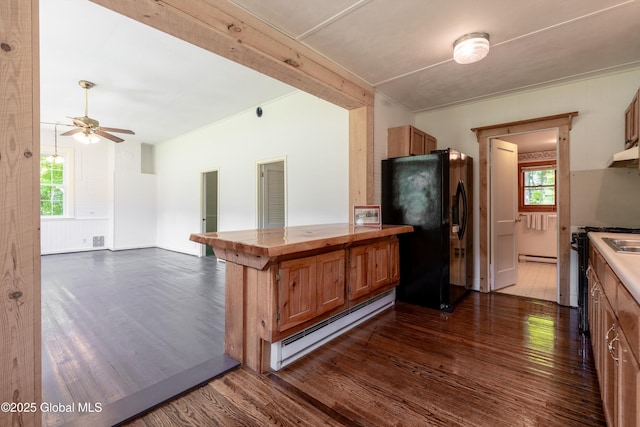 1301 State Route 313, Cambridge, NY 12816 - kitchen with black fridge with ice dispenser, baseboard heating, dark wood-style flooring, brown cabinetry, and ceiling fan