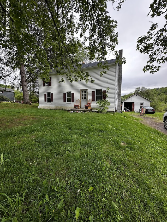 503 N Main St, Gloversville, NY 12078 - back of property with a detached garage, a yard, driveway, an outdoor structure, and a chimney