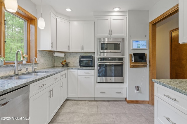 6175 Hawes Rd, Guilderland, NY 12009 - kitchen with appliances with stainless steel finishes, a sink, white cabinetry, decorative backsplash, and recessed lighting