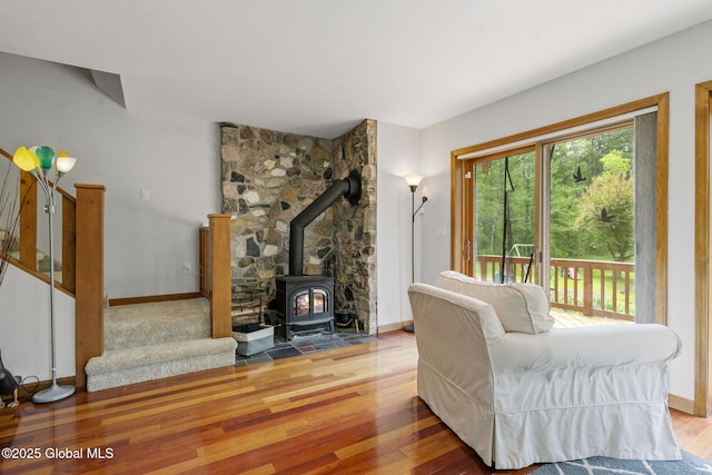 6175 Hawes Rd, Guilderland, NY 12009 - living area featuring wood finished floors, baseboards, a wood stove, and stairway