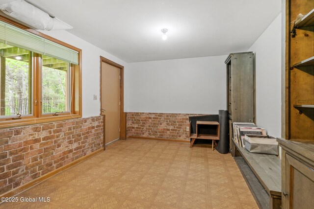 6175 Hawes Rd, Guilderland, NY 12009 - spare room featuring light flooring, brick wall, and wainscoting
