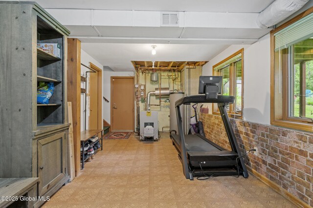 6175 Hawes Rd, Guilderland, NY 12009 - exercise room featuring light floors, water heater, brick wall, and a heating unit