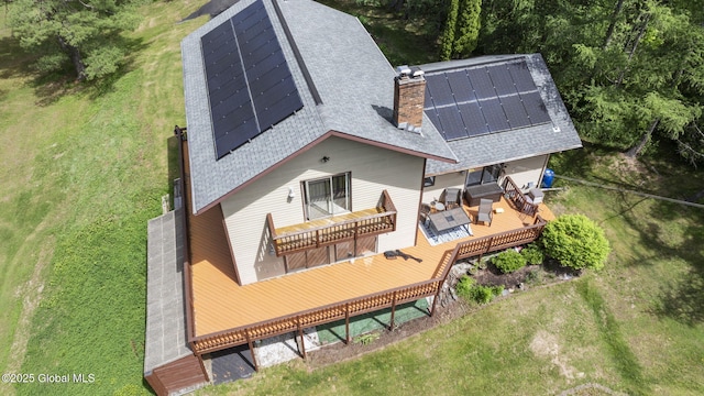 6175 Hawes Rd, Guilderland, NY 12009 - back of property featuring a shingled roof, roof mounted solar panels, outdoor lounge area, a deck, and a chimney