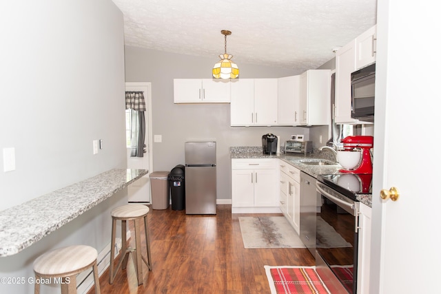126 Hillside Rd, Duanesburg, NY 12137 - kitchen featuring appliances with stainless steel finishes, vaulted ceiling, a textured ceiling, white cabinets, and dark wood finished floors