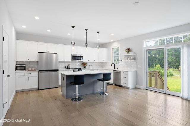 39 Berkeley Way, Wilton, NY 12866 - kitchen featuring stainless steel appliances, a breakfast bar area, open shelves, tasteful backsplash, and recessed lighting