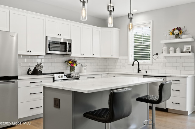 39 Berkeley Way, Wilton, NY 12866 - kitchen with stainless steel appliances, a kitchen bar, open shelves, a kitchen island, and white cabinets
