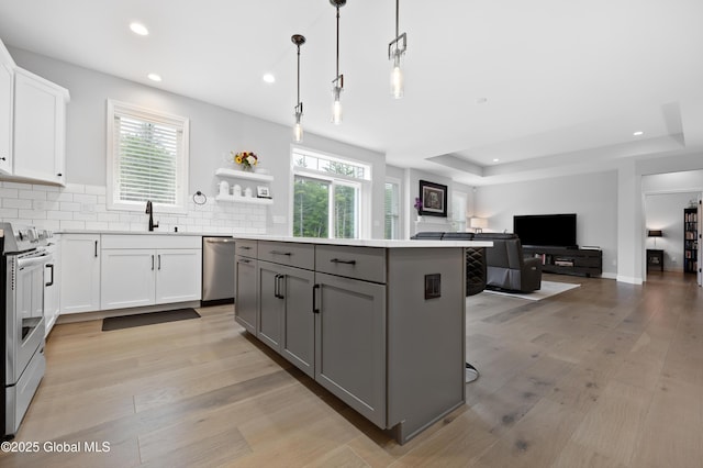 39 Berkeley Way, Wilton, NY 12866 - kitchen with appliances with stainless steel finishes, a kitchen island, gray cabinets, white cabinetry, and light wood-style flooring