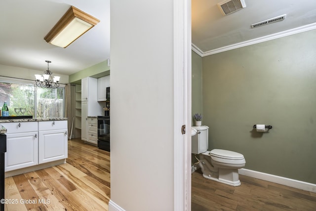 110 Deer Run Dr, Milton, NY 12020 - bathroom with wood finished floors, toilet, crown molding, a chandelier, and baseboards