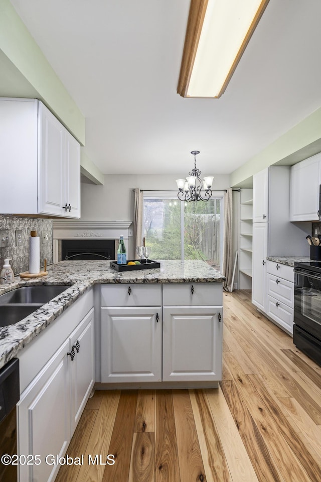 110 Deer Run Dr, Milton, NY 12020 - kitchen with black / electric stove, white cabinetry, light wood-style flooring, and tasteful backsplash