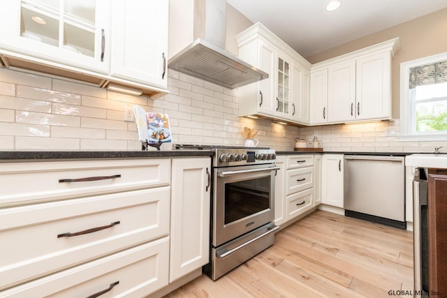 5 Hunter Ct, Milton, NY 12020 - kitchen with wall chimney range hood, stainless steel appliances, light wood-type flooring, glass insert cabinets, and white cabinetry