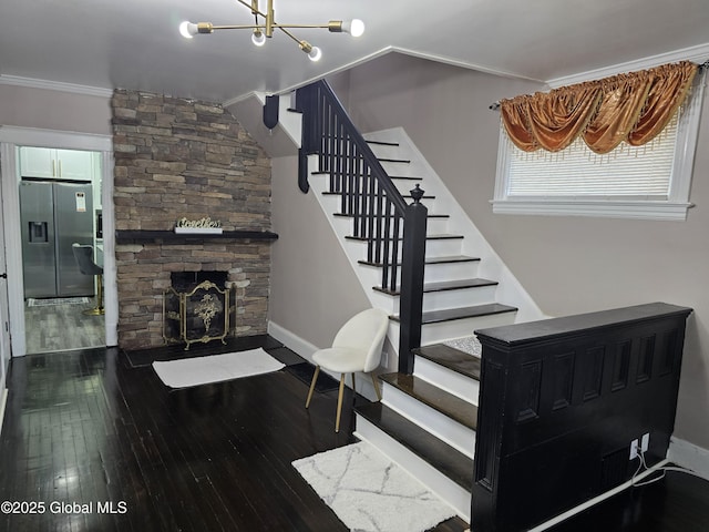 1117 Mcclellan St, Schenectady, NY 12309 - stairway featuring hardwood / wood-style flooring, baseboards, a stone fireplace, a chandelier, and crown molding