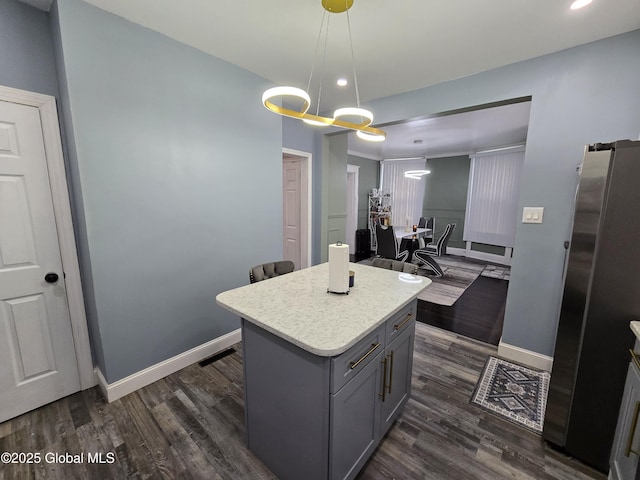 1117 Mcclellan St, Schenectady, NY 12309 - kitchen with gray cabinets, freestanding refrigerator, light countertops, a center island, and dark wood-type flooring