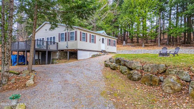 12 Birch Pl, Day, NY 12835 - view of home's exterior with a deck, a fire pit, gravel driveway, and view of scattered trees