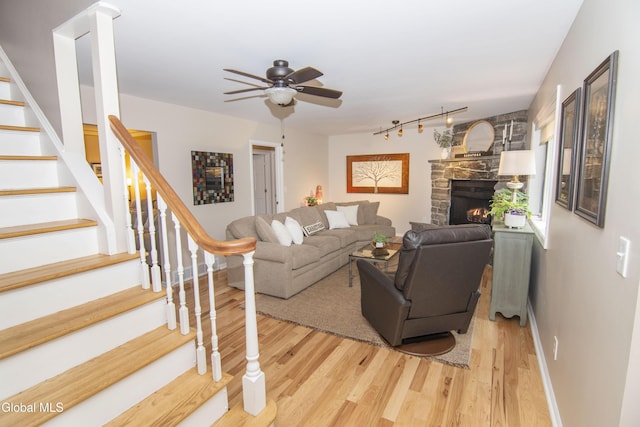 124 Edie Rd, Wilton, NY 12866 - living area featuring light wood-type flooring, stairway, track lighting, a ceiling fan, and a fireplace