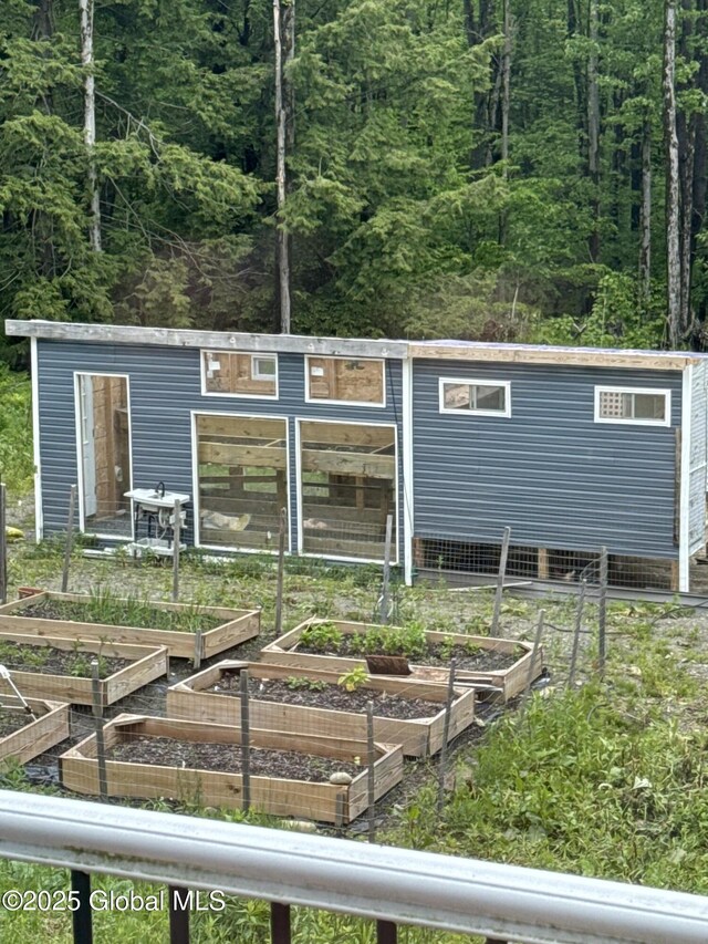 14 Calvin Cole Rd, Stephentown, NY 12169 - back of house featuring a garden, an outdoor structure, and a view of trees