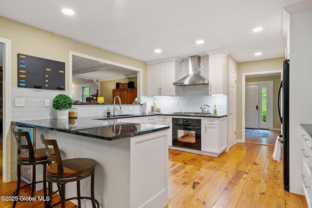 9 Longwood Dr, Saratoga Springs, Inside, NY 12866 - kitchen featuring oven, wall chimney exhaust hood, white cabinetry, a breakfast bar area, and stainless steel gas stovetop
