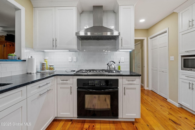 9 Longwood Dr, Saratoga Springs, Inside, NY 12866 - kitchen with wall chimney range hood, stainless steel appliances, light wood finished floors, and white cabinets