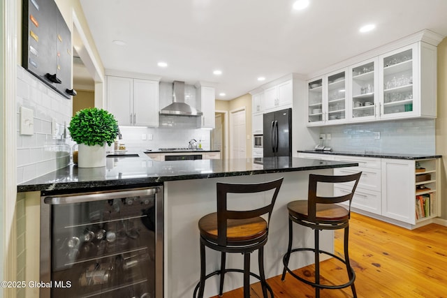 9 Longwood Dr, Saratoga Springs, Inside, NY 12866 - kitchen featuring wall chimney range hood, wine cooler, freestanding refrigerator, tasteful backsplash, and glass insert cabinets