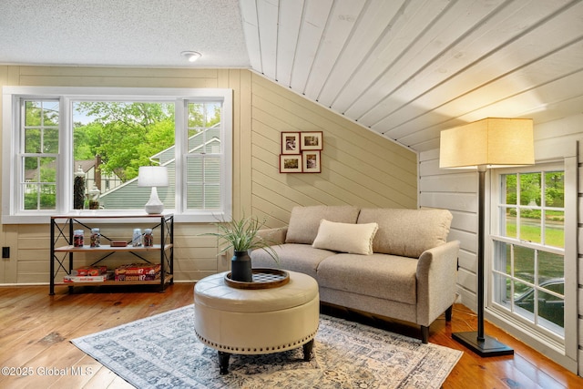 9 Longwood Dr, Saratoga Springs, Inside, NY 12866 - sitting room with healthy amount of natural light, wooden walls, lofted ceiling, and hardwood / wood-style flooring