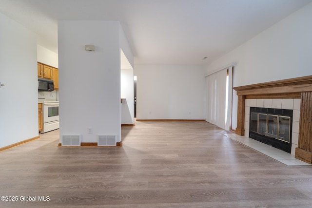 1976 Curry Rd Unit E-136, Schenectady, NY 12303 - unfurnished living room featuring light wood-style flooring, a tile fireplace, and baseboards